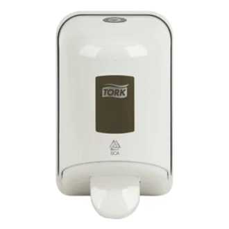 Ein weißer Seifenspender der Marke TORK, der an einer Wand montiert ist. Er hat eine glatte Oberfläche und einen grauen Bereich mit dem Logo. Am unteren Ende befindet sich ein Ausgabemechanismus für die Seife.